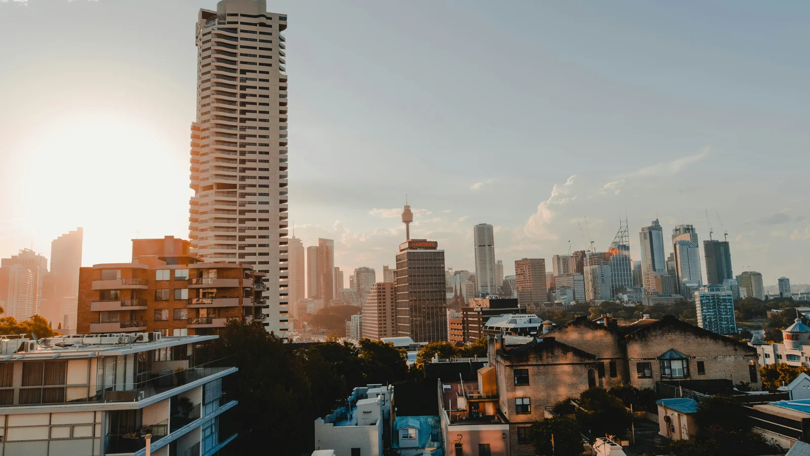 Sydney, Australia; residential rooftops and city skyline at sunset